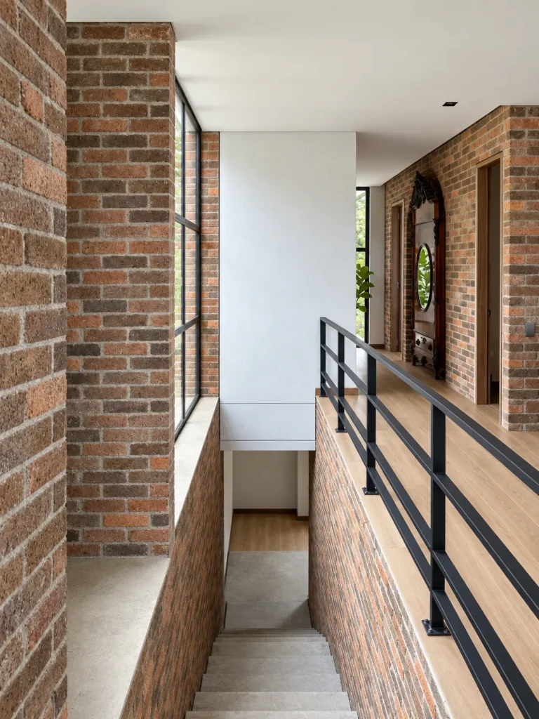 Casa Botero – circulation with metal railing and brick walls