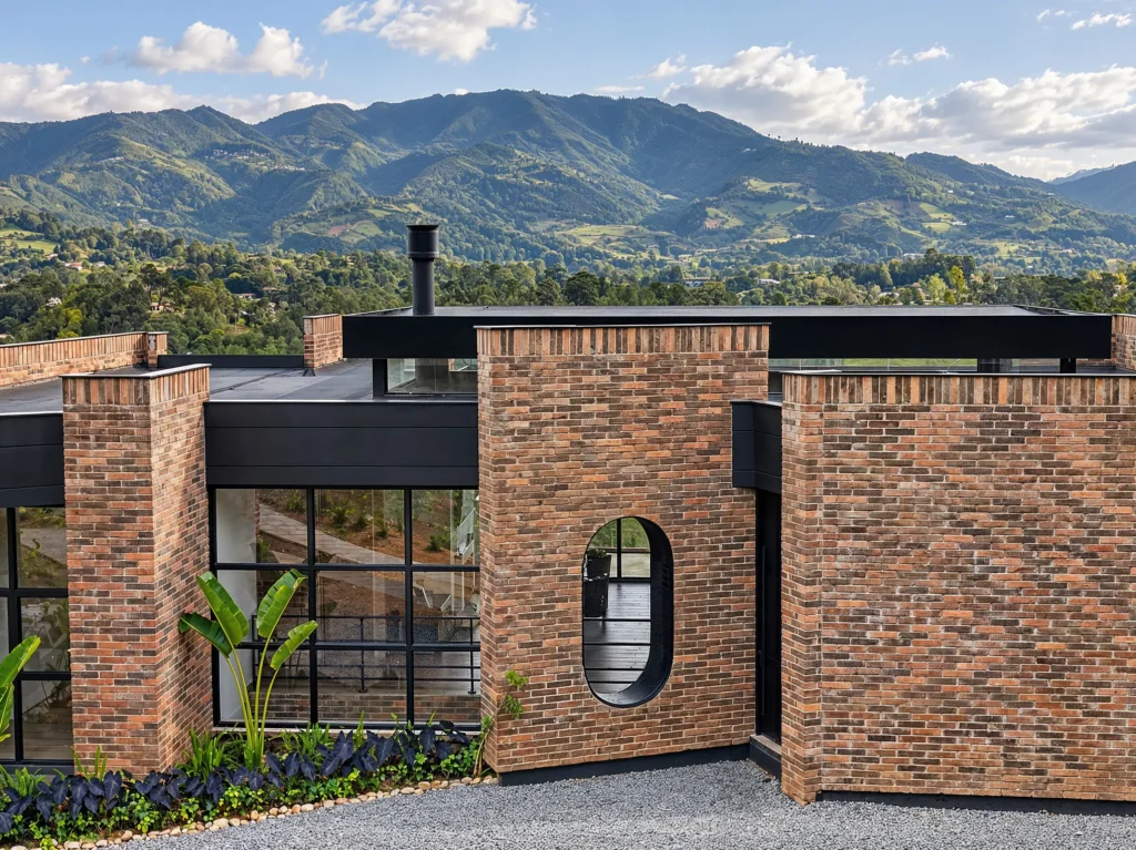 Casa Botero – brick façade with oval window and mountains beyond