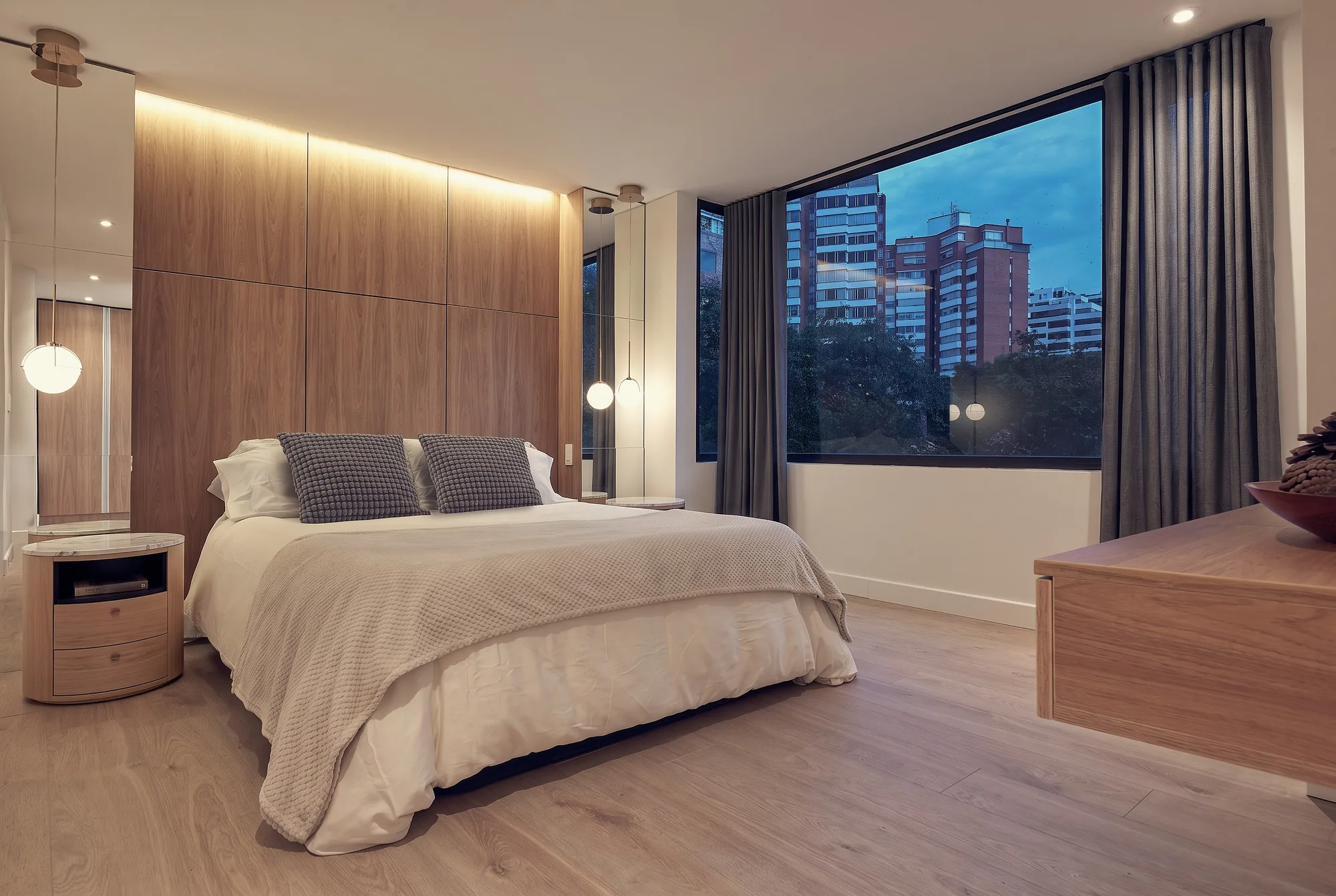 El Nogal Apartment – master bedroom with wood headboard and city views