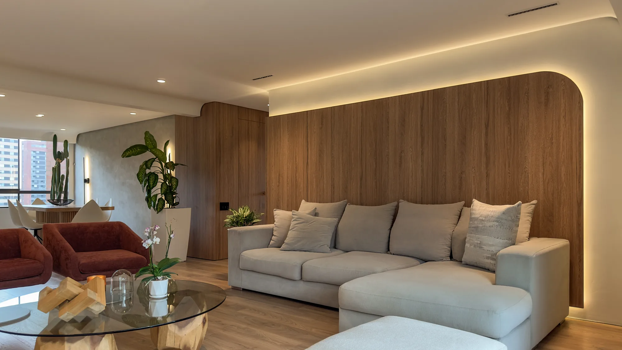 La Campiña W&D – Sala con panel de madera de remate curvo e iluminación indirecta