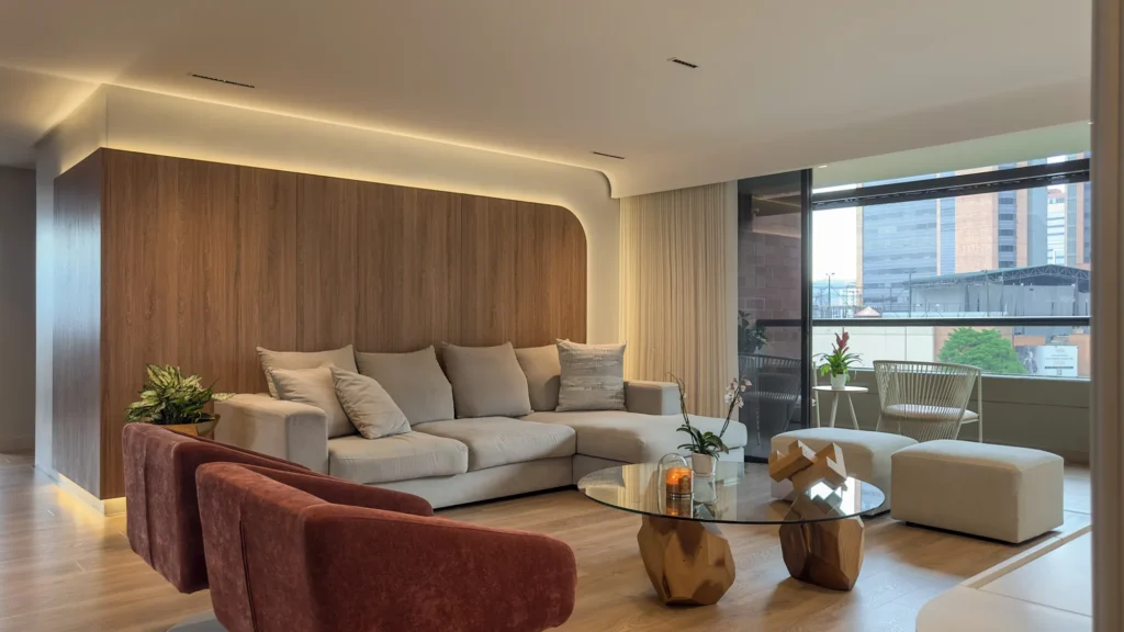 La Campiña W&D – sala con panel de madera, luz indirecta y poltronas terracota