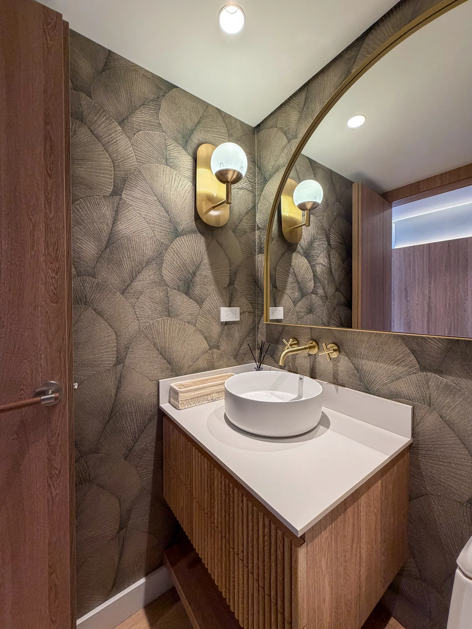 La Campiña W&D – Baño social con papel de colgadura botánico y mueble acanalado